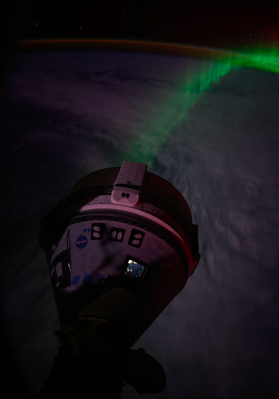 Vue de la Terre et ses aurores, depuis le module Harmony de l’ISS auquel est amarrée la capsule Starliner pour une durée indéterminée.