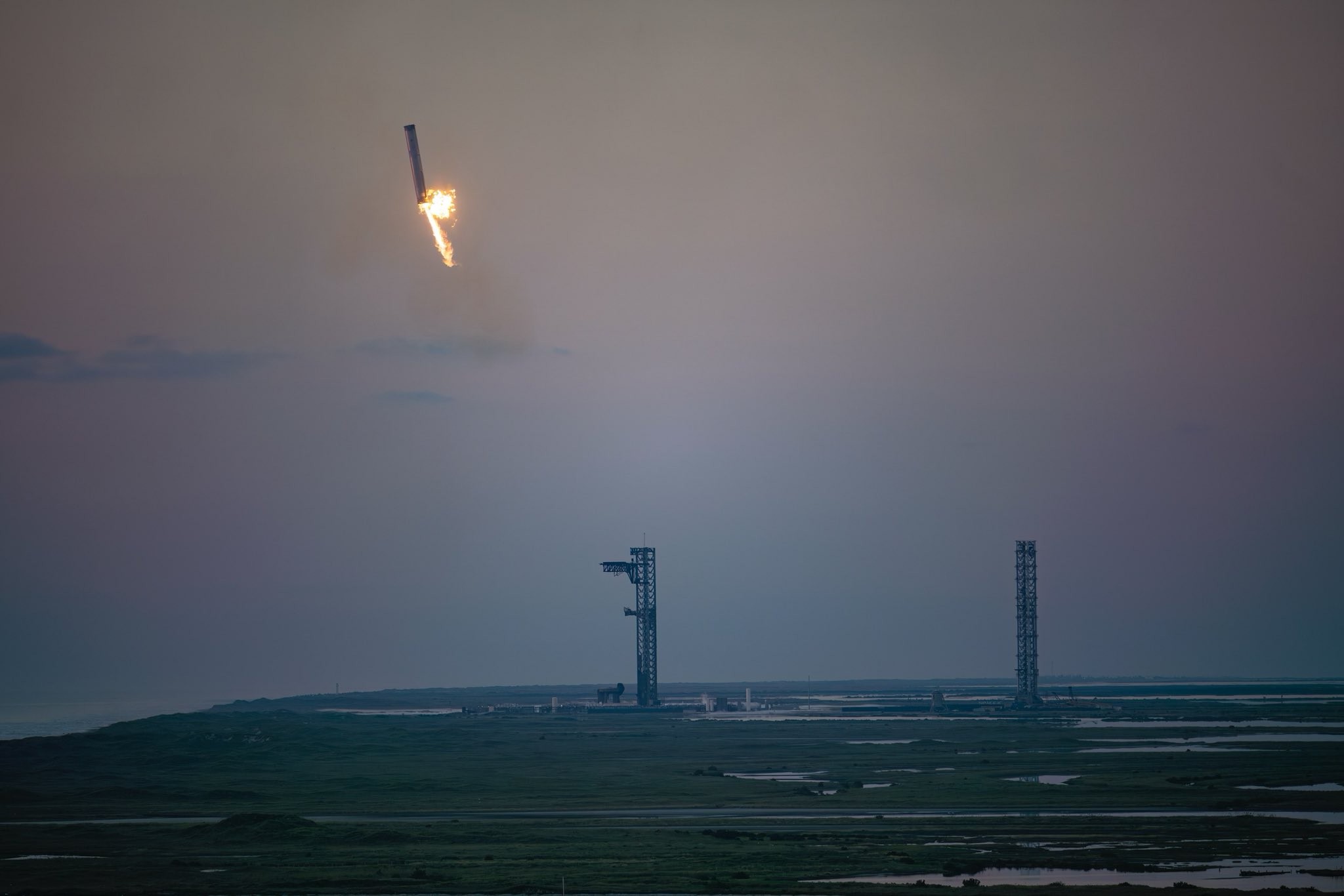 Le Starship s'approche de la tour de récupération. La flamme sur le côté est un incendie, mais qui n'a eu aucune conséquence. © Space X.